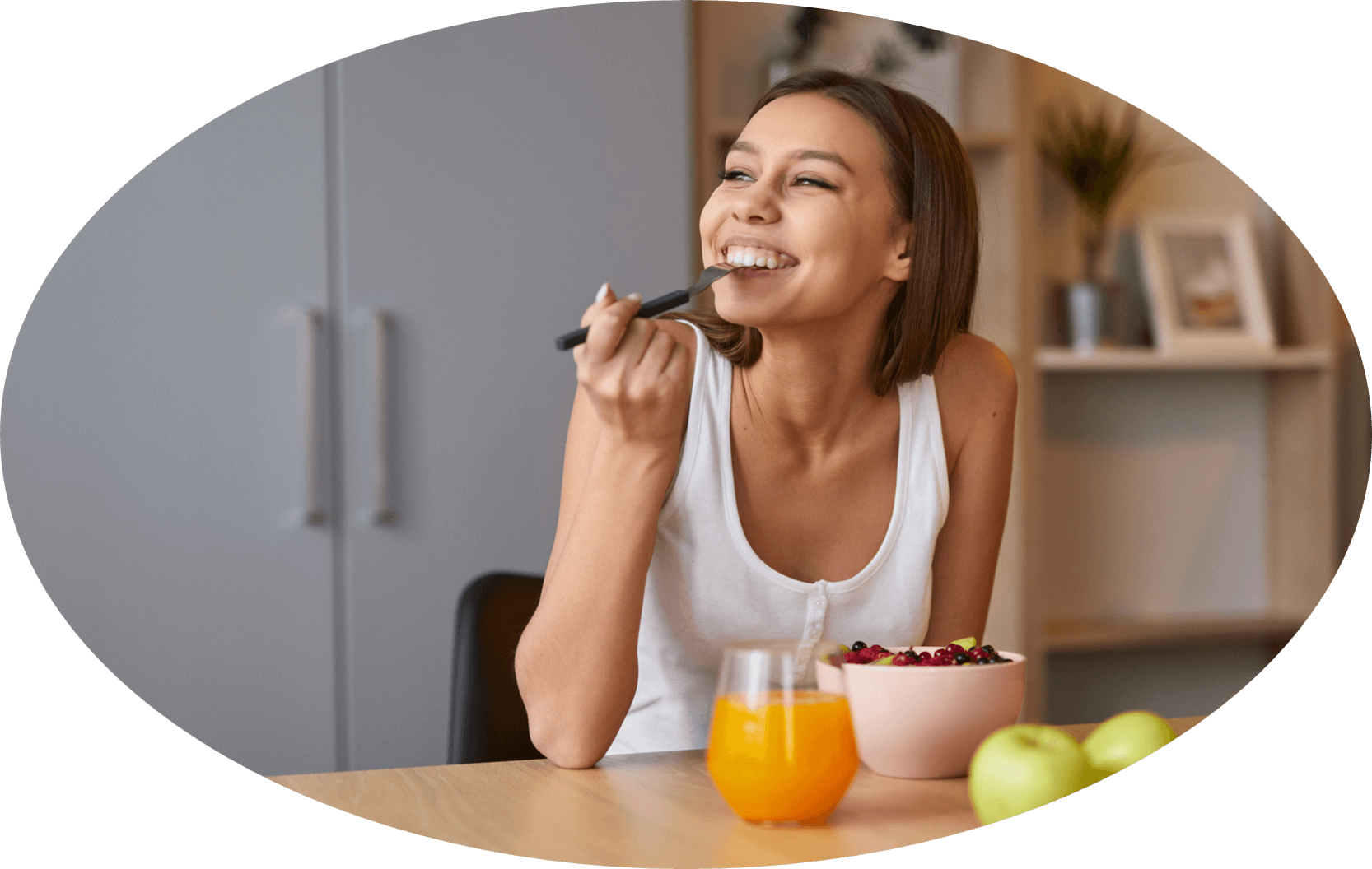 Eine Frau, die fröhlich eine Obstschale isst.